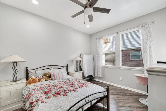 a bedroom with a bed and a flat tv screen on dresser