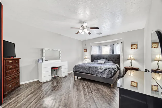 a spacious bedroom with a bed and wooden floor