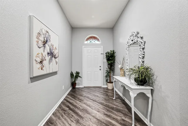 a view of a hallway with wooden floor and front door