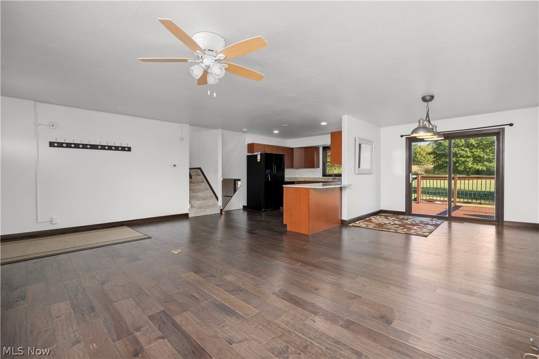 6760 Mason Road Berlin Heights, OH 44814 - Photo 5 of 49 Unfurnished living room with dark wood-style floors, ceiling fan, and stairs