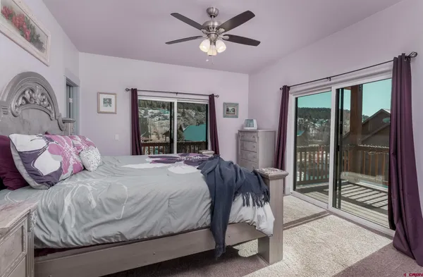 a bedroom with a bed and a large window with the outer view