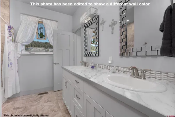 a bathroom with a double vanity sink mirror and shower