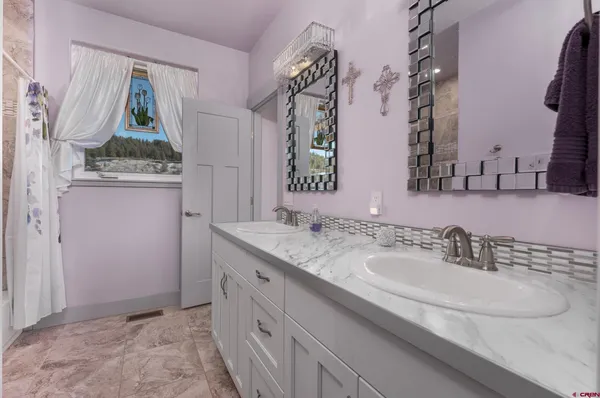 a bathroom with double vanity sink and a mirror