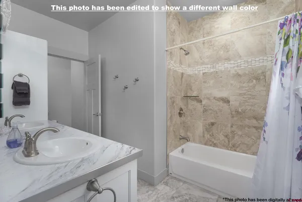 a bathroom with a tub a sink and a large mirror