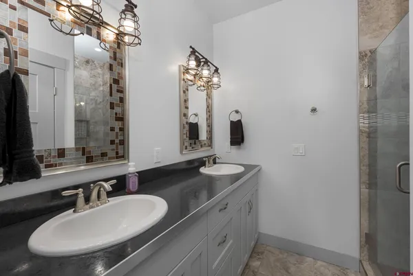 a bathroom with double vanity sinks and a mirror