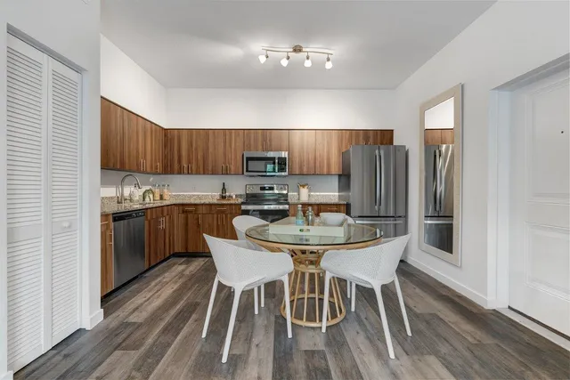 a kitchen with granite countertop wooden floors a center island and stainless steel appliances