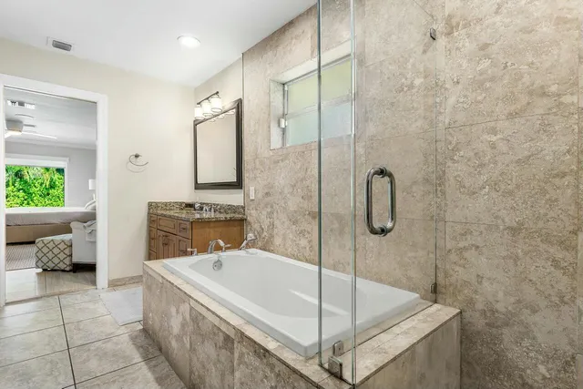 a spacious bathroom with a tub shower and mirror