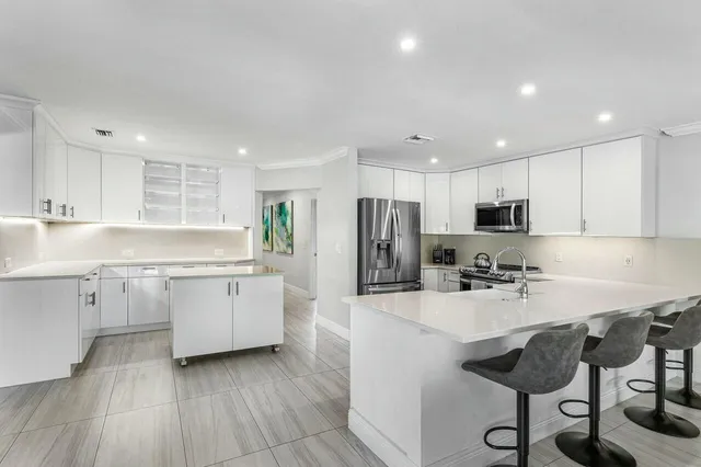 a kitchen with sink refrigerator and cabinets