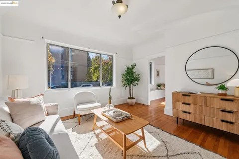 a living room with furniture a window and wooden floor