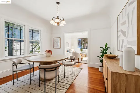 a dining room with furniture potted plants and wooden floor
