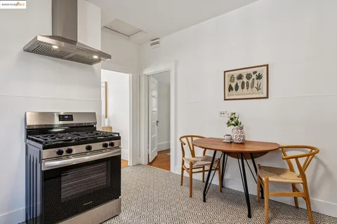 a kitchen with stainless steel appliances a stove a table and chairs