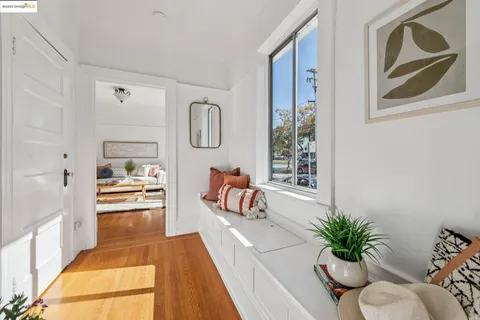 a hallway with a potted plant on a stool and a potted plant
