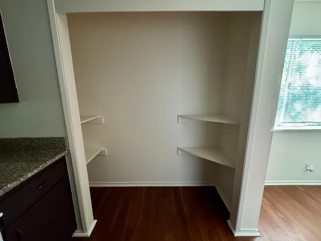 an empty room with wooden floor and entrance