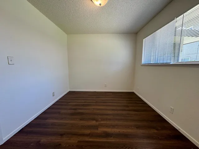 a view of a room with wooden floor and a window