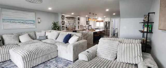 a living room with furniture a flat screen tv and a fireplace