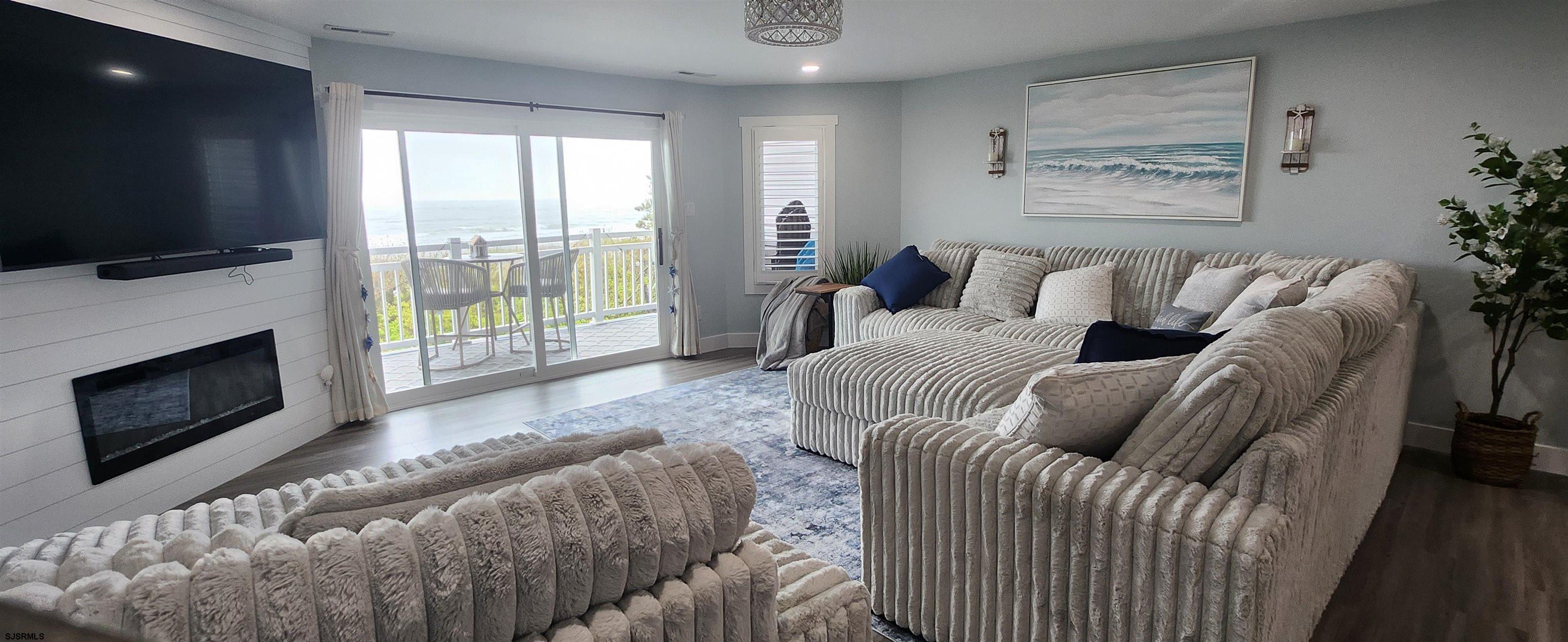 504 East Brigantine Avenue, Unit 504 Brigantine, NJ 08203 - Photo 22 of 43 a living room with furniture a flat screen tv and a fireplace