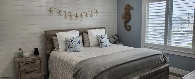a bedroom with a bed and a flat tv screen on a dresser
