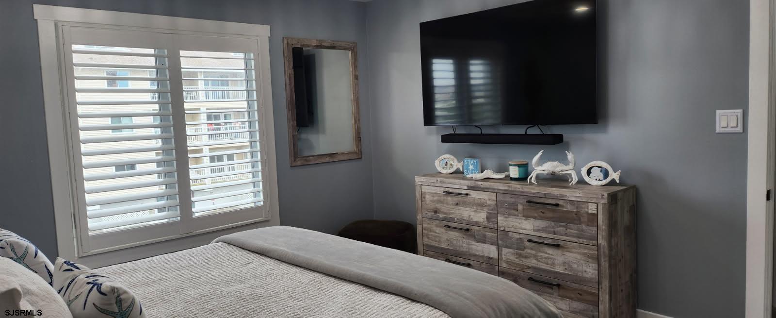 504 East Brigantine Avenue, Unit 504 Brigantine, NJ 08203 - Photo 38 of 43 a bedroom with a bed and a flat tv screen on a dresser