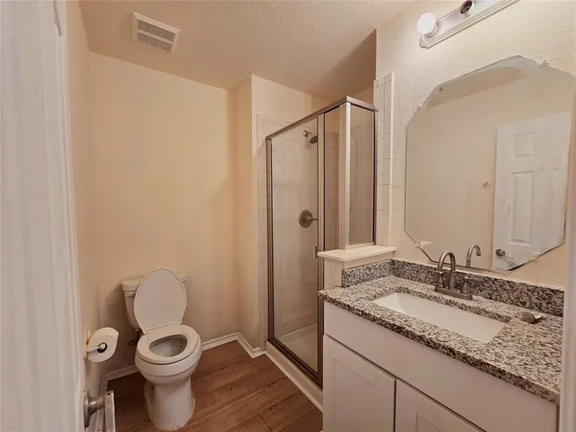 a bathroom with a granite countertop sink toilet and a mirror