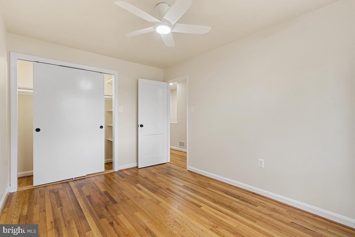9003 Manchester Road, Unit 9003 Silver Spring, MD 20901 - Photo 19 of 53 an empty room with wooden floor and a ceiling fan