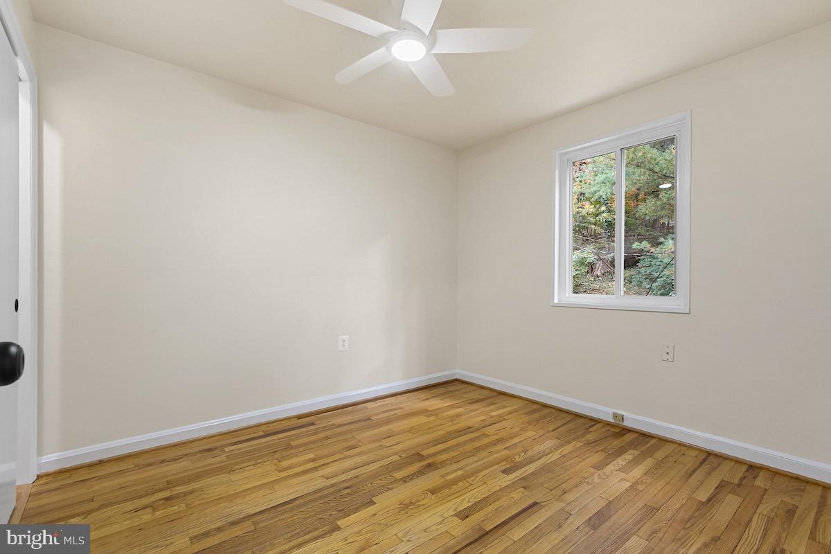 9003 Manchester Road, Unit 9003 Silver Spring, MD 20901 - Photo 22 of 53 a view of empty room with wooden floor and fan
