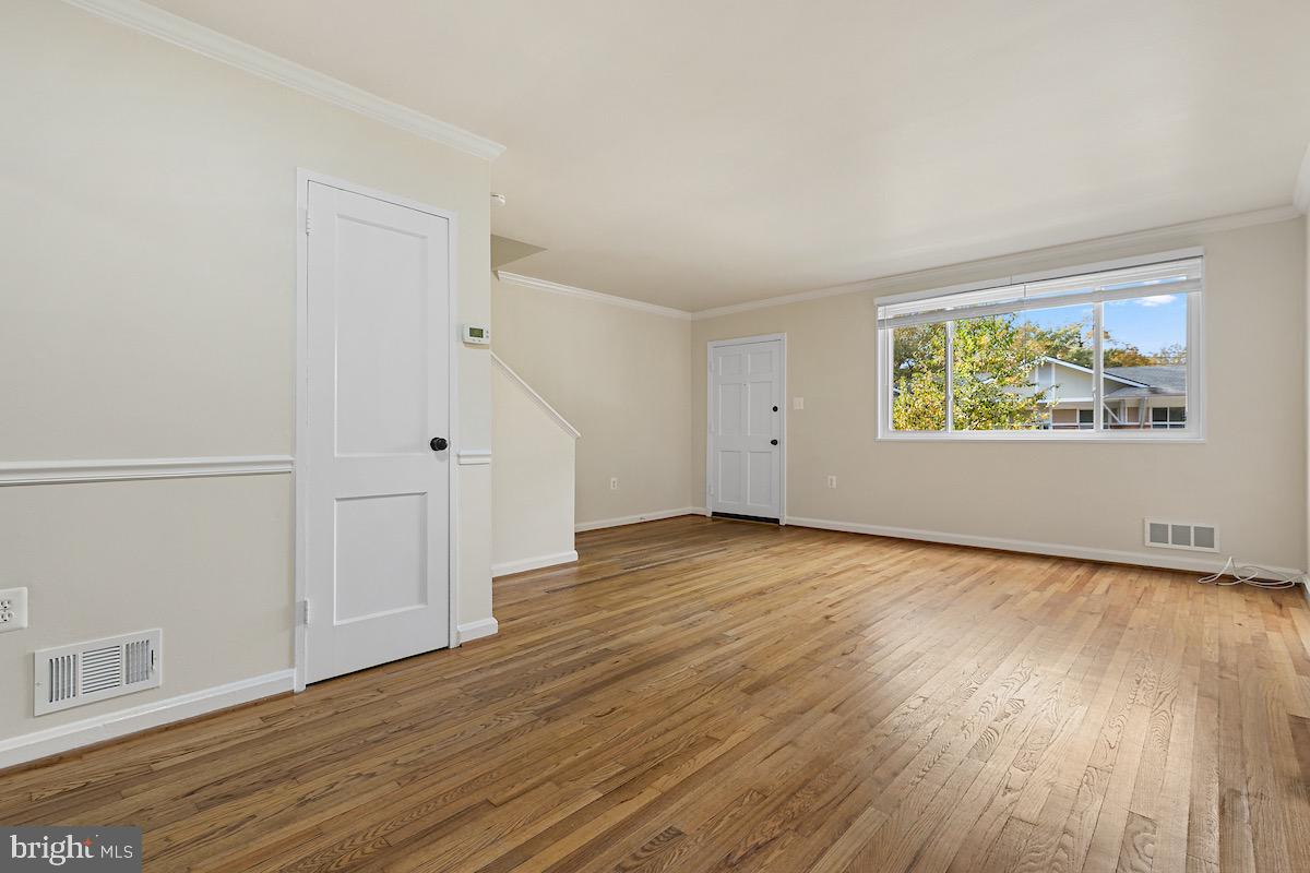 9003 Manchester Road, Unit 9003 Silver Spring, MD 20901 - Photo 3 of 53 an empty room with wooden floor and windows