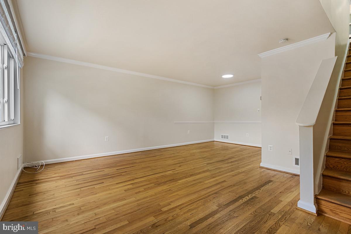 9003 Manchester Road, Unit 9003 Silver Spring, MD 20901 - Photo 5 of 53 a view of an empty room with wooden floor and stairs