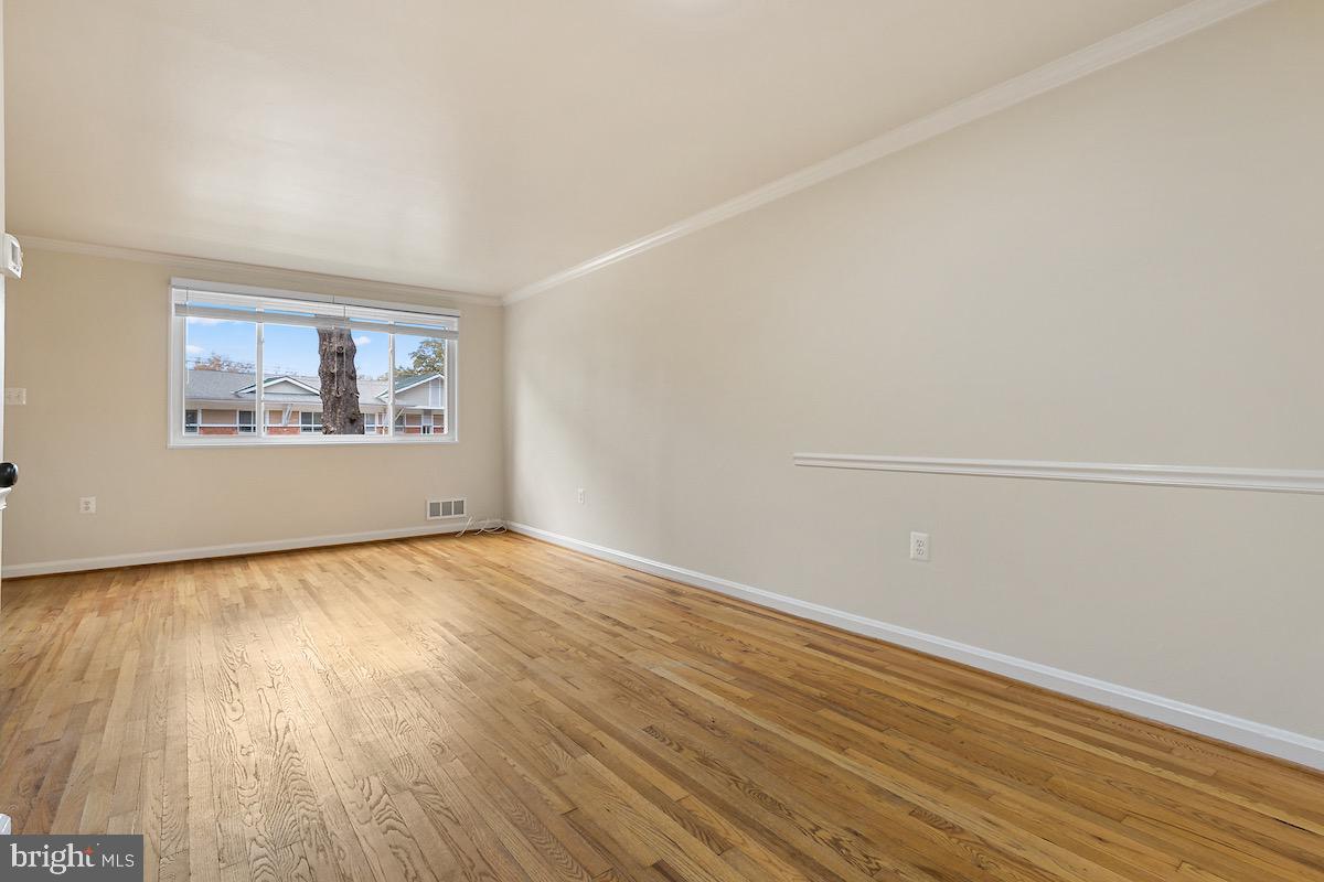9003 Manchester Road, Unit 9003 Silver Spring, MD 20901 - Photo 9 of 53 an empty room with wooden floor and windows