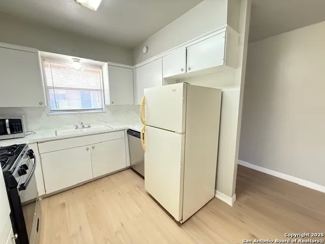 a utility room with cabinets washer and dryer