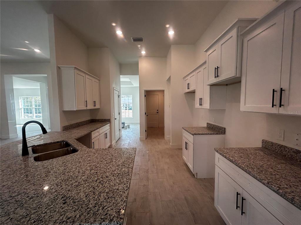 498 Santiguay Street Punta Gorda, FL 33983 - Photo 6 of 28 a kitchen with granite countertop a sink stove and cabinets