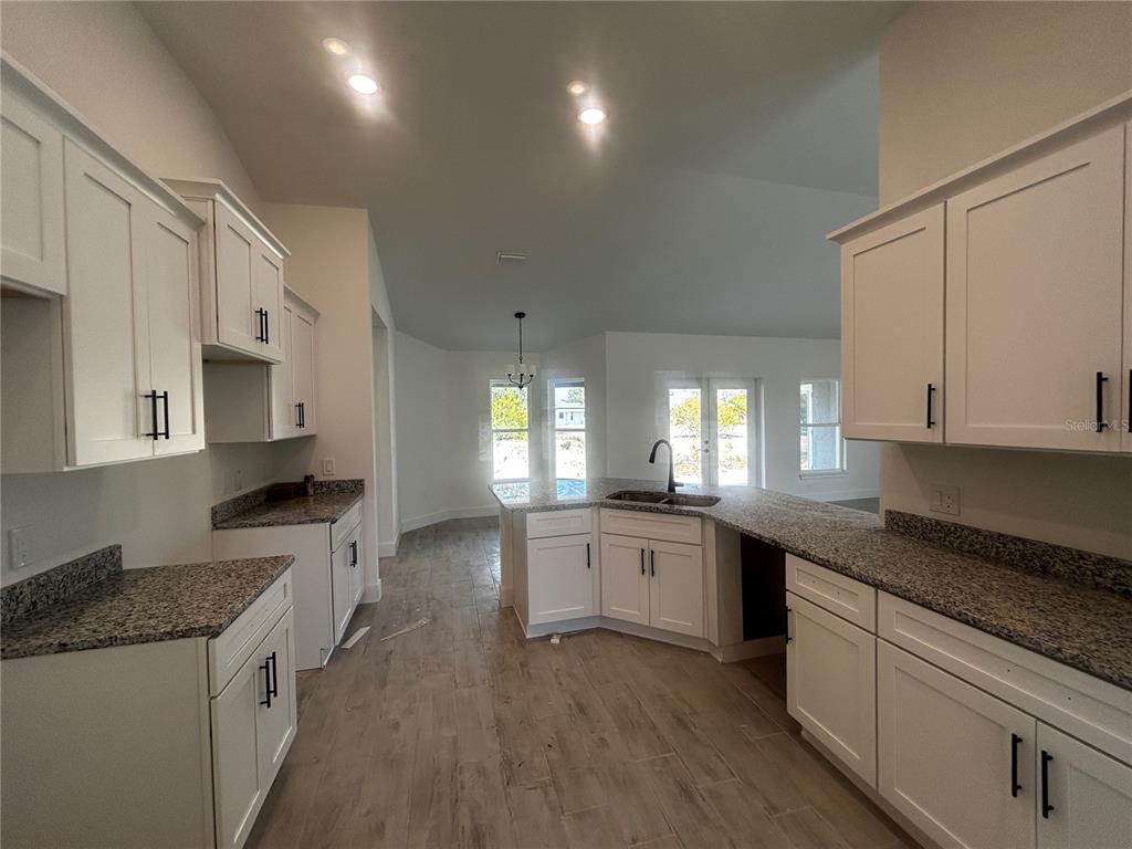 498 Santiguay Street Punta Gorda, FL 33983 - Photo 7 of 28 a large kitchen with stainless steel appliances granite countertop a lot of counter space and wooden floors
