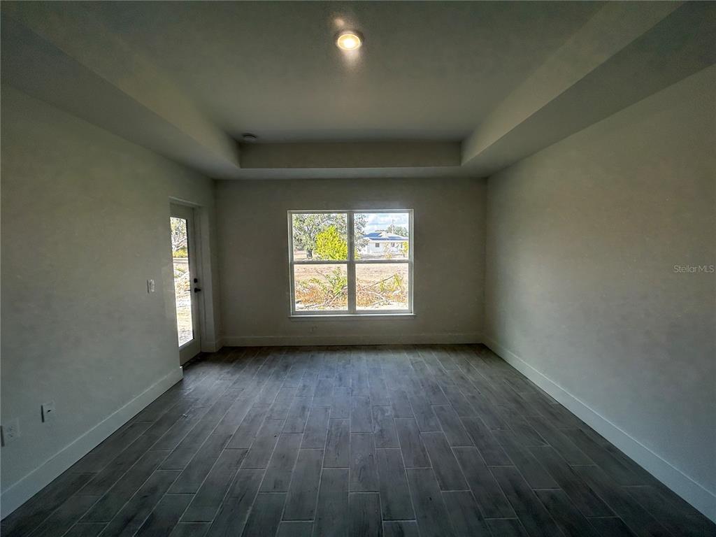 498 Santiguay Street Punta Gorda, FL 33983 - Photo 8 of 28 an empty room with wooden floor and windows