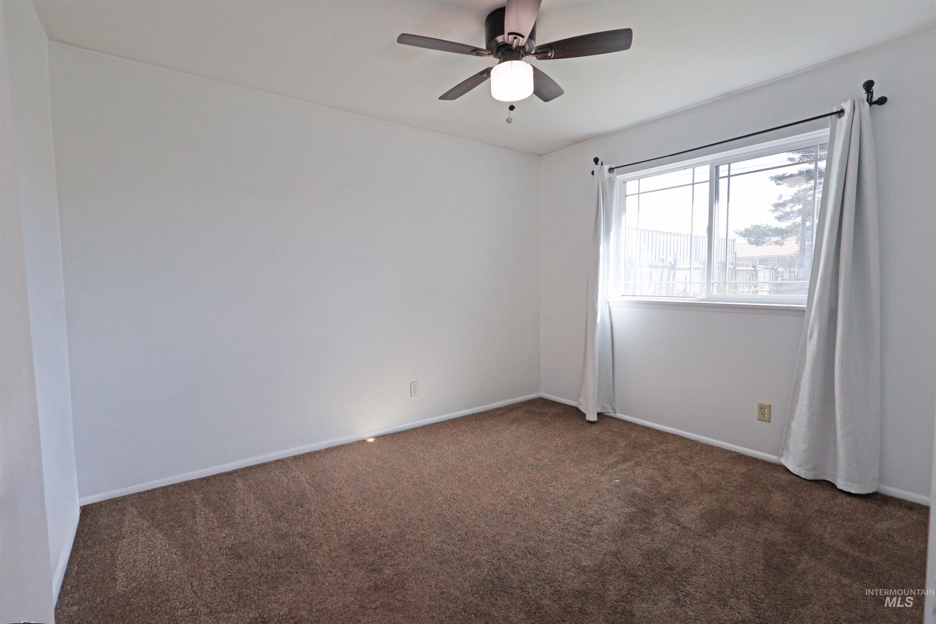 412 Linden Street Rupert, ID 83350 - Photo 12 of 17 Carpeted empty room featuring baseboards and ceiling fan