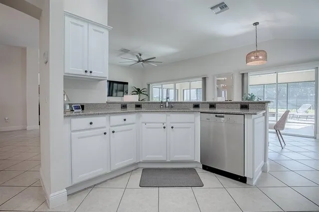 a kitchen with white cabinets and sink