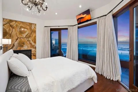 a bedroom with a bed and dresser with wooden floor