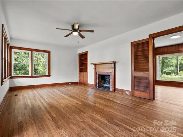 wooden floor fireplace and windows in an empty room