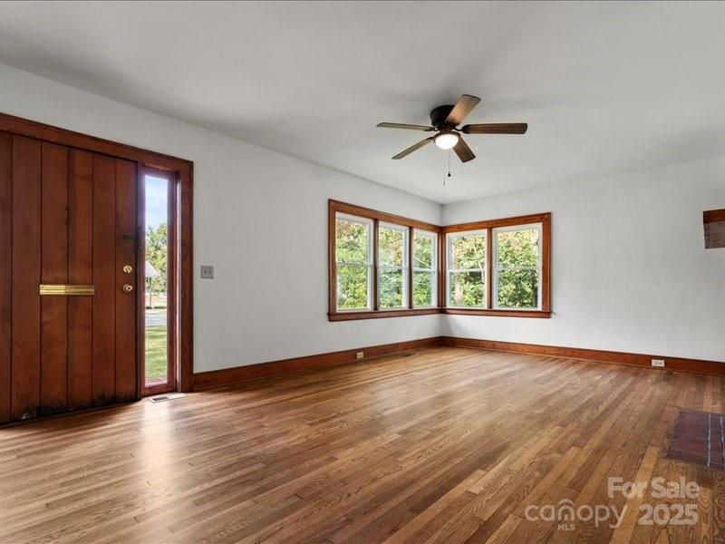 37 Lynn Avenue Cheraw, SC 29520 - Photo 5 of 30 an empty room with wooden floor ceiling fan and windows