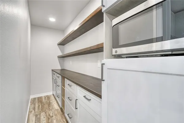 a kitchen with stainless steel appliances cabinets and wooden floor