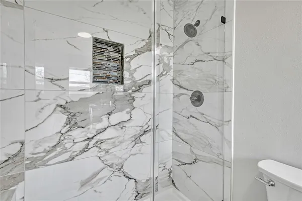 a bathroom with a sink vanity granite toilet and shower
