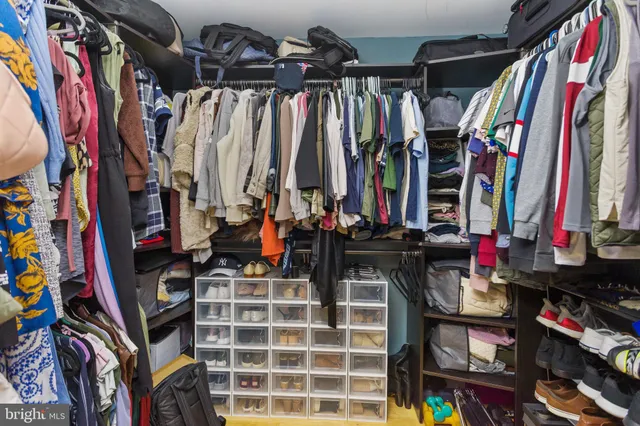 a view of walk in closet with clothes and shoes