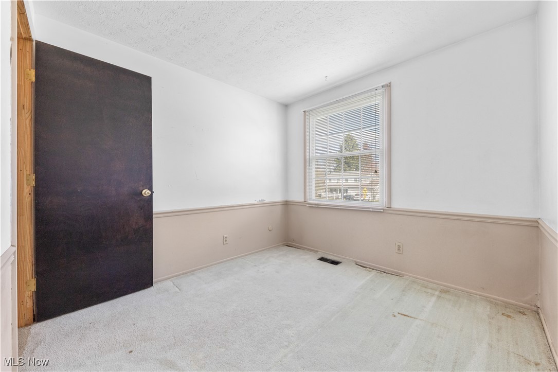 4301 Baird Road Stow, OH 44224 - Photo 29 of 50 Spare room with baseboards, visible vents, a textured ceiling, and carpet flooring