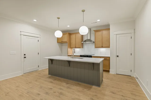 a view of a kitchen counter top space a sink a stove and wooden floor