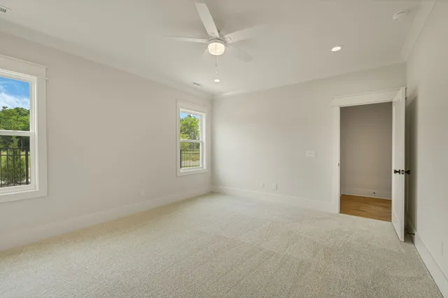 an empty room with a ceiling fan and window