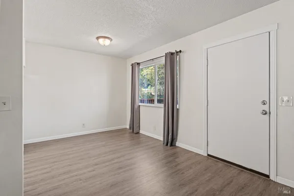 a kitchen with wooden floors and white stainless steel appliances