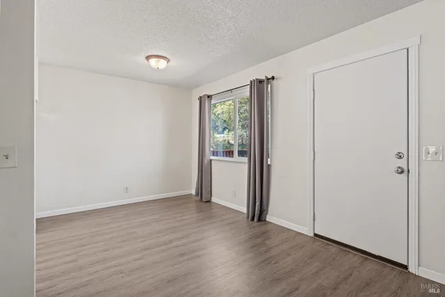 a kitchen with wooden floors and white stainless steel appliances