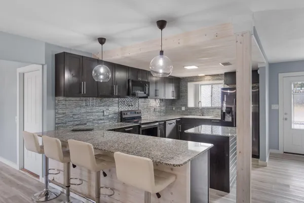 a kitchen with granite countertop a sink cabinetry and refrigerator