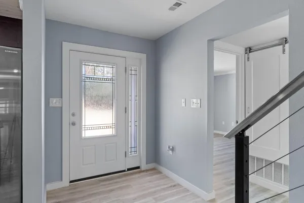 a view of an entryway with wooden floor and door