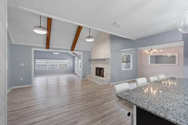 a view of a livingroom with furniture wooden floor fireplace and a window