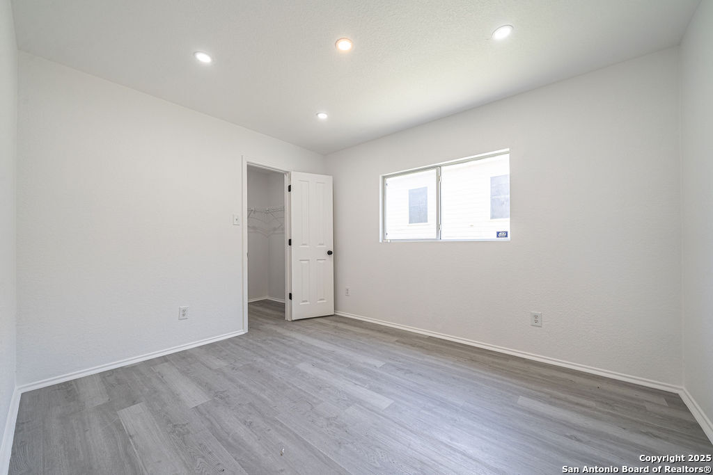 3914 Cinco Rios San Antonio, TX 78223 - Photo 11 of 12 an empty room with wooden floor and windows