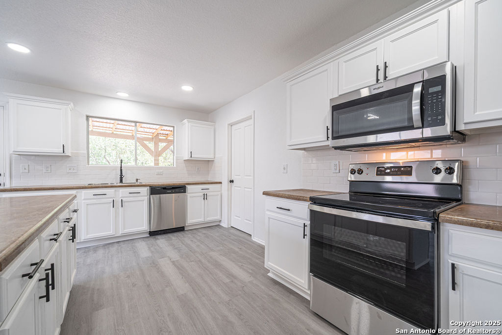 3914 Cinco Rios San Antonio, TX 78223 - Photo 4 of 12 a kitchen with stainless steel appliances a stove a sink and a microwave